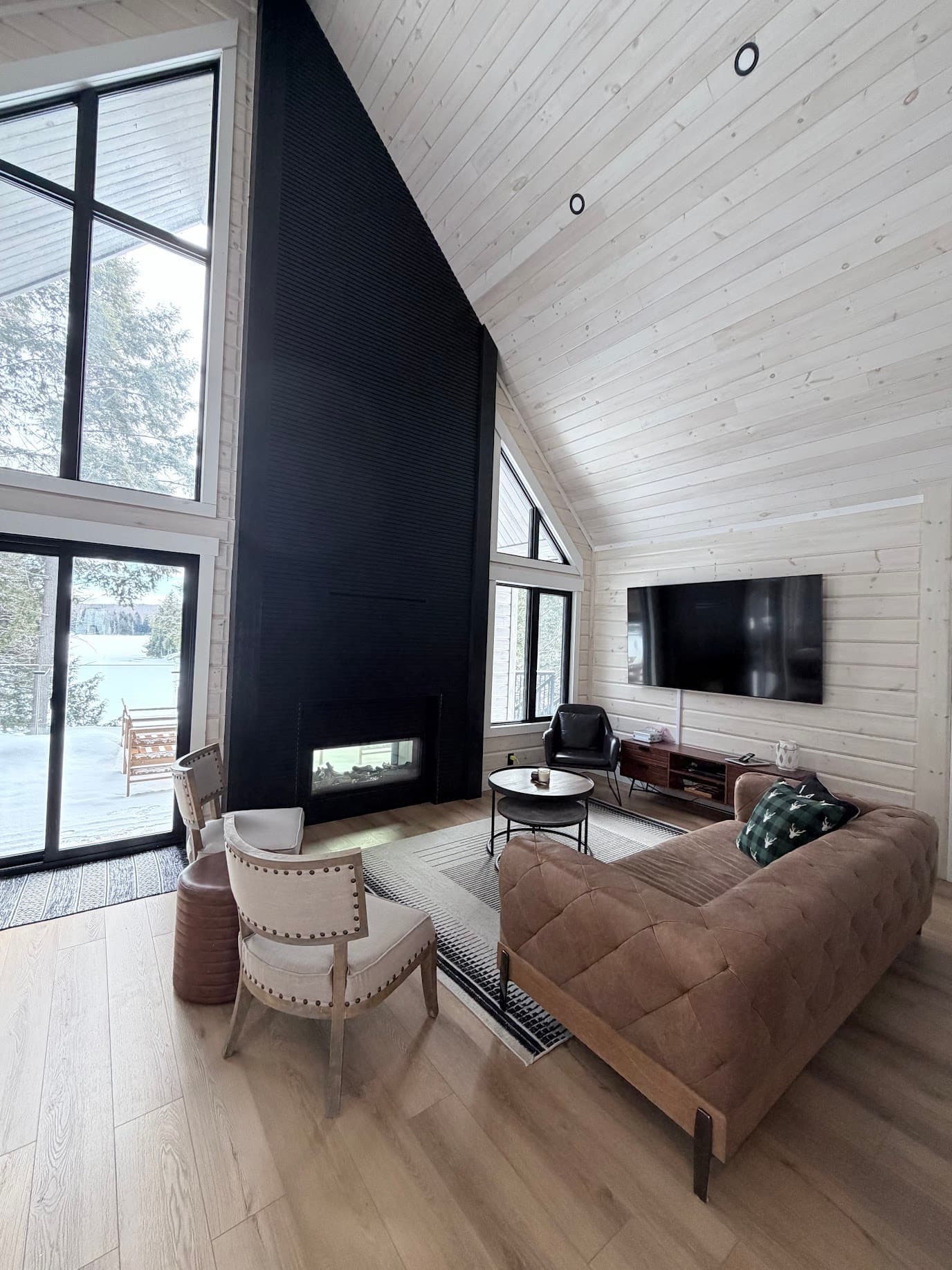 Cottage living room with vaulted ceilings and black fireplace